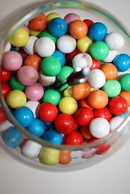brightly colored gum-balls in a classic gum-ball dispenser 